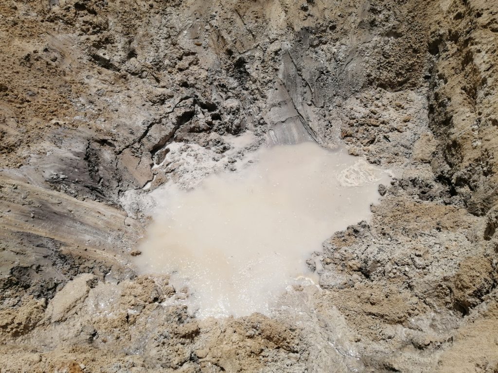 Water slowly seeping out from the ground forming a pool that will gradually rise.