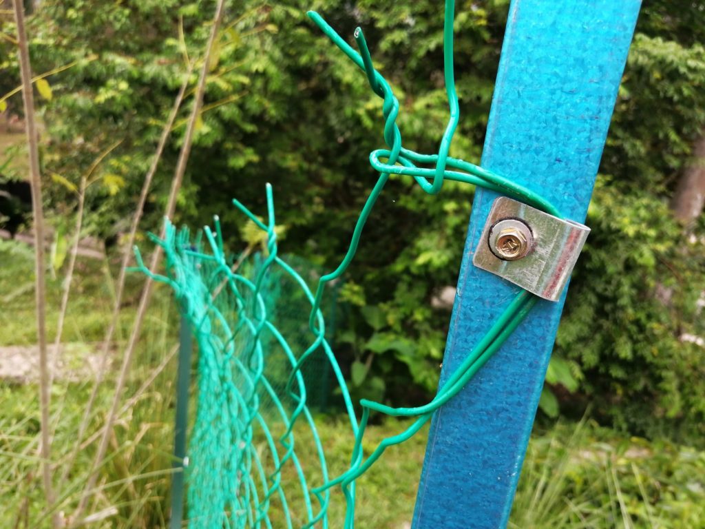 The chainlink fence is bolted with a clip.